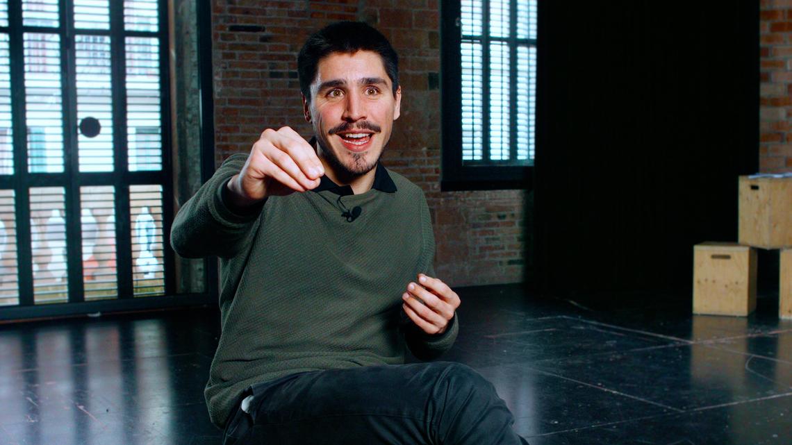 Se ve un bello fotograma de la persona entrevistada, Dante Maschio, gesticulando con el brazo derecho hacía adelante y mirando a le entrevistadore. Le entrevistadore no aparece en el fotograma.